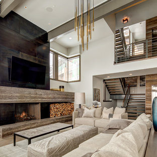 Offenes, Großes Modernes Wohnzimmer mit beiger Wandfarbe, Kamin, Wand-TV, dunklem Holzboden, Kaminumrandung aus Beton und braunem Boden in Salt Lake City