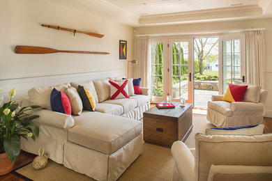 Ejemplo de sala de estar cerrada marinera de tamaño medio sin chimenea y televisor con paredes blancas, suelo de madera en tonos medios y suelo beige
