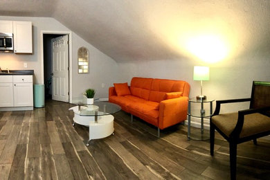 Small trendy loft-style medium tone wood floor and multicolored floor family room photo in Miami with gray walls