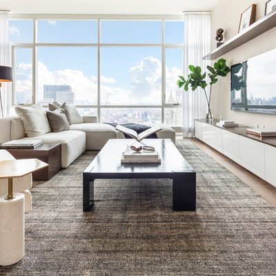 Trendy open concept light wood floor family room photo in New York with a bar, beige walls, no fireplace and a wall-mounted tv