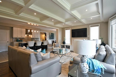 Family room - large transitional open concept dark wood floor and brown floor family room idea in Toronto with beige walls, a standard fireplace, a stone fireplace and a wall-mounted tv