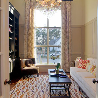 Family room - traditional enclosed medium tone wood floor family room idea in Houston with beige walls and no fireplace