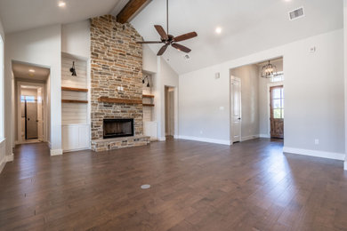Inspiration for a large cottage open concept medium tone wood floor and vaulted ceiling family room remodel in Dallas with beige walls, a standard fireplace and a stone fireplace