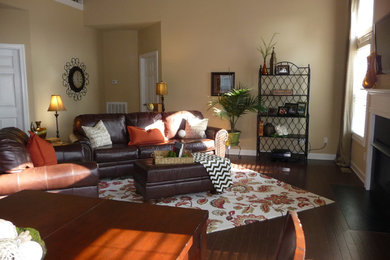 Mittelgroßes, Offenes Klassisches Wohnzimmer mit beiger Wandfarbe, dunklem Holzboden, Kamin, verputzter Kaminumrandung und TV-Wand in Nashville