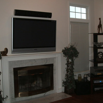 Inspiration for a mid-sized timeless open concept dark wood floor family room remodel in New York with white walls, a standard fireplace, a stone fireplace and a wall-mounted tv