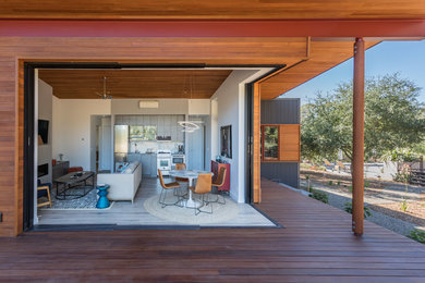 Diseño de sala de estar abierta contemporánea con paredes blancas, chimenea lineal, marco de chimenea de yeso y televisor colgado en la pared