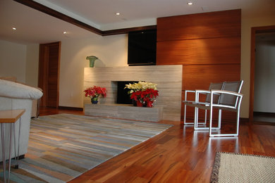 Ejemplo de sala de estar abierta contemporánea con paredes beige, suelo de madera en tonos medios, todas las chimeneas, marco de chimenea de piedra y televisor colgado en la pared