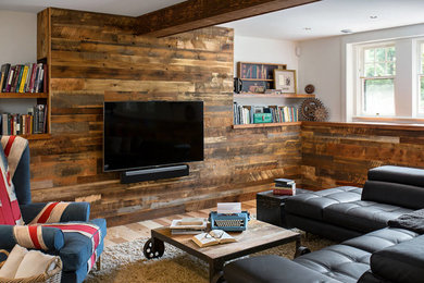 Imagen de sala de juegos en casa abierta industrial con paredes blancas, suelo de madera en tonos medios y pared multimedia
