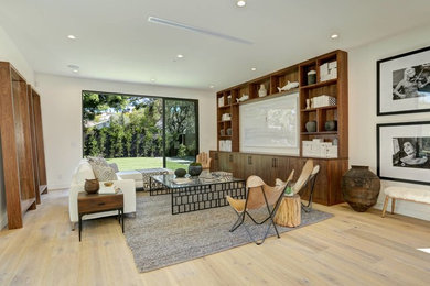 Example of a minimalist family room design in Los Angeles with a media wall
