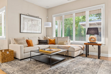 Diseño de sala de estar abierta clásica renovada con paredes beige, suelo de madera en tonos medios y suelo marrón