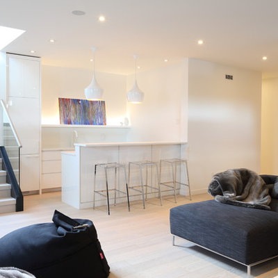 Family room - large contemporary open concept light wood floor and beige floor family room idea in Vancouver with a bar, white walls, a standard fireplace, a stone fireplace and a wall-mounted tv