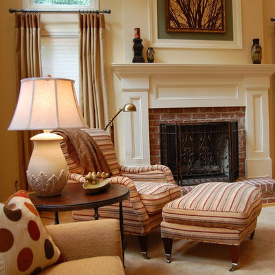 Example of a classic family room design in DC Metro with beige walls, a standard fireplace and a brick fireplace