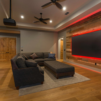 Mountain style open concept medium tone wood floor and brown floor family room photo in Austin with gray walls