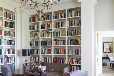 Esempio di un grande soggiorno chic con libreria, pareti bianche, parquet chiaro, nessun camino e nessuna TV