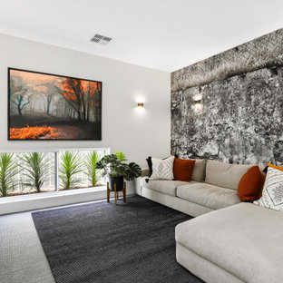 Photo of a mid-sized contemporary enclosed family room in Perth with white walls, carpet, a wall-mounted tv and grey floor.
