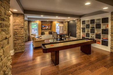 Immagine di un grande soggiorno classico chiuso con sala giochi, pareti beige, pavimento in legno massello medio e TV a parete