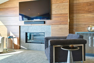 Inspiration for a mid-sized contemporary enclosed carpeted family room remodel in San Diego with beige walls, a standard fireplace, a tile fireplace and a wall-mounted tv