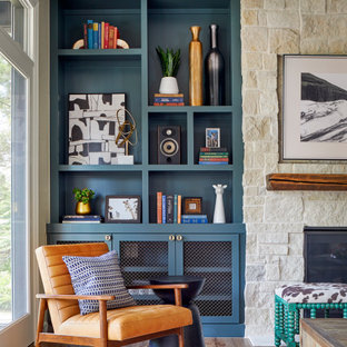Inspiration for a large eclectic open concept medium tone wood floor and brown floor family room remodel in Denver with gray walls, a standard fireplace, a stone fireplace and a wall-mounted tv
