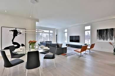 Modelo de sala de estar abierta minimalista extra grande con paredes blancas, suelo de madera clara, chimenea lineal y televisor colgado en la pared