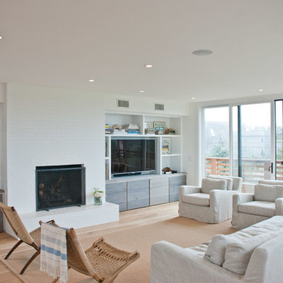 Inspiration for a contemporary open concept medium tone wood floor family room remodel in New York with white walls, a standard fireplace, a brick fireplace and a wall-mounted tv
