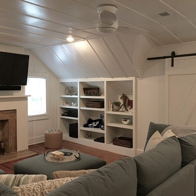 Family room - mid-sized craftsman enclosed medium tone wood floor family room idea in Louisville with white walls, a standard fireplace, a wood fireplace surround and a wall-mounted tv