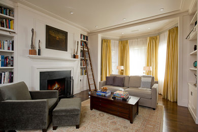 На фото: изолированная гостиная комната среднего размера в стиле неоклассика (современная классика) с с книжными шкафами и полками, белыми стенами, темным паркетным полом и стандартным камином без телевизора с
