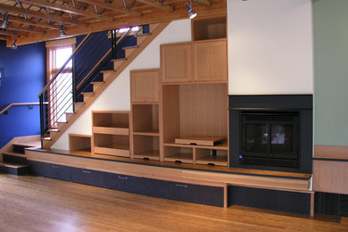 Ejemplo de sala de estar abierta contemporánea grande con paredes azules, suelo de madera en tonos medios y todas las chimeneas