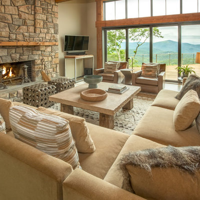 Large mountain style open concept medium tone wood floor and brown floor family room photo in Charlotte with beige walls, a standard fireplace, a stone fireplace and a wall-mounted tv