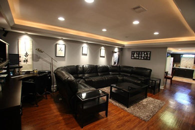 Modelo de sala de juegos en casa abierta tradicional renovada de tamaño medio sin chimenea y televisor con paredes grises y suelo marrón
