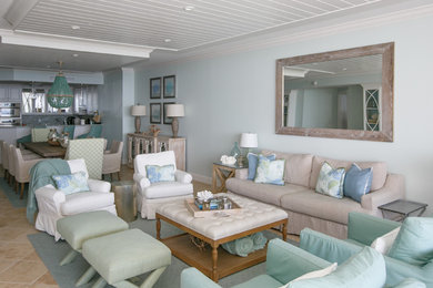 Modelo de sala de estar abierta marinera de tamaño medio con paredes azules, suelo de baldosas de cerámica, suelo beige y pared multimedia