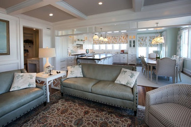Ejemplo de sala de estar abierta costera de tamaño medio sin chimenea y televisor con paredes beige, suelo de madera oscura y suelo marrón