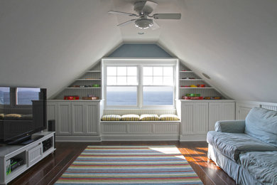 Ejemplo de sala de juegos en casa tipo loft costera de tamaño medio con paredes azules, suelo de madera en tonos medios y televisor independiente