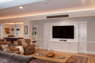 Huge elegant open concept medium tone wood floor family room photo in New York with beige walls and a wall-mounted tv