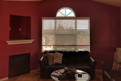 デンバーにあるラグジュアリーなインダストリアルスタイルのおしゃれなファミリールーム (赤い壁、淡色無垢フローリング、コーナー設置型暖炉) の写真