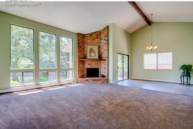 Example of a huge classic open concept laminate floor and brown floor family room design in Denver with a bar, green walls, a corner fireplace, a brick fireplace and a concealed tv