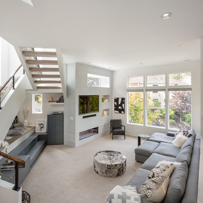 Inspiration for a large contemporary enclosed carpeted and beige floor family room remodel in Portland with white walls, a ribbon fireplace and a media wall