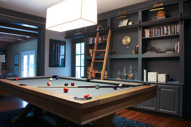 Mid-sized minimalist enclosed dark wood floor and brown floor game room photo in Raleigh with gray walls, a standard fireplace, a brick fireplace and a wall-mounted tv