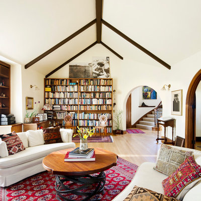 Example of a tuscan medium tone wood floor family room design in San Francisco with white walls