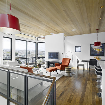 Trendy loft-style medium tone wood floor family room photo in San Francisco with white walls and a wall-mounted tv