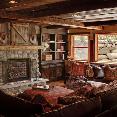 Family room - rustic enclosed dark wood floor family room idea in Minneapolis with brown walls, a standard fireplace and a stone fireplace