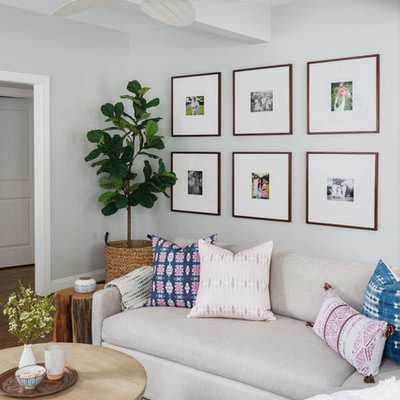 Mid-sized transitional open concept medium tone wood floor and brown floor family room photo in Philadelphia with gray walls, a standard fireplace, a stone fireplace and a wall-mounted tv