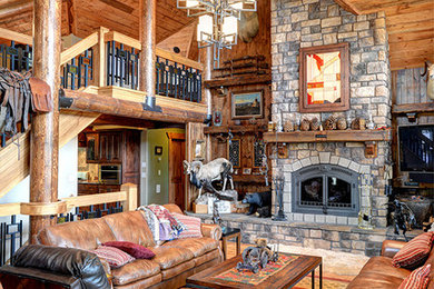 Example of a large mountain style loft-style light wood floor family room design in Salt Lake City with brown walls, a standard fireplace, a stone fireplace and a tv stand
