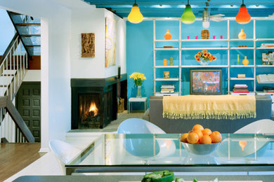 Imagen de sala de estar moderna con paredes azules, chimenea de esquina, marco de chimenea de metal y vigas vistas