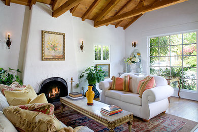 Inspiration for a mid-sized eclectic enclosed medium tone wood floor family room remodel in Los Angeles with white walls, a standard fireplace and a concrete fireplace