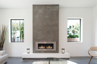 Example of a large minimalist concrete floor family room design in Tampa with white walls, a ribbon fireplace, a concrete fireplace and a wall-mounted tv