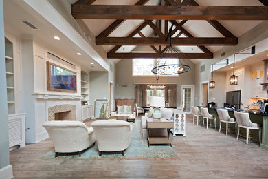 Inspiration for a huge coastal open concept medium tone wood floor and brown floor family room remodel in Houston with gray walls, a standard fireplace, a tile fireplace and a wall-mounted tv