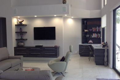Diseño de sala de estar abierta contemporánea extra grande con paredes grises, suelo de baldosas de porcelana y televisor colgado en la pared