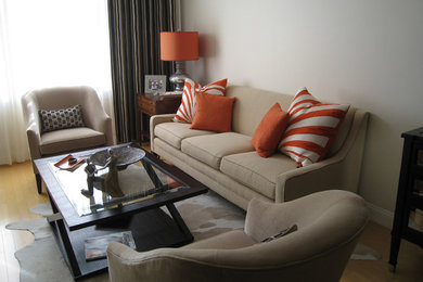 Diseño de sala de estar cerrada minimalista de tamaño medio sin chimenea y televisor con paredes beige y suelo de madera clara