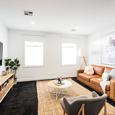 Example of a mid-sized trendy open concept carpeted and black floor family room design in Melbourne with white walls, no fireplace and a wall-mounted tv
