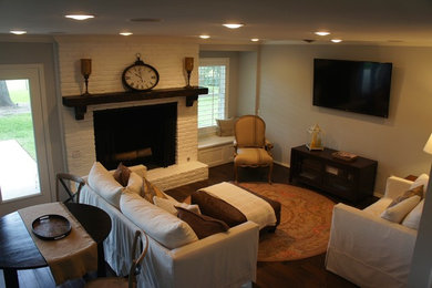 Ejemplo de sala de estar abierta tradicional con paredes azules, suelo de madera oscura, todas las chimeneas, marco de chimenea de ladrillo y televisor colgado en la pared